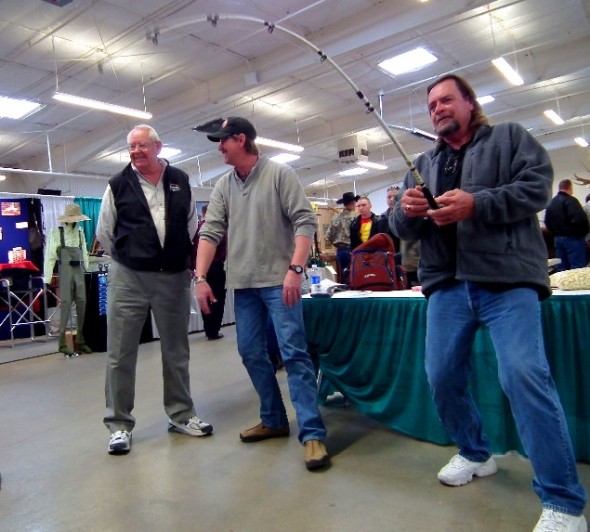 Bob Gerding watches as Mike Giddings enjoys reeling in a big one on a simulator machine featured at the a recent show.