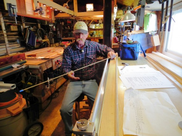 Bruce Smith inspects a piece of bamboo for a custom crafted fishing rod. 