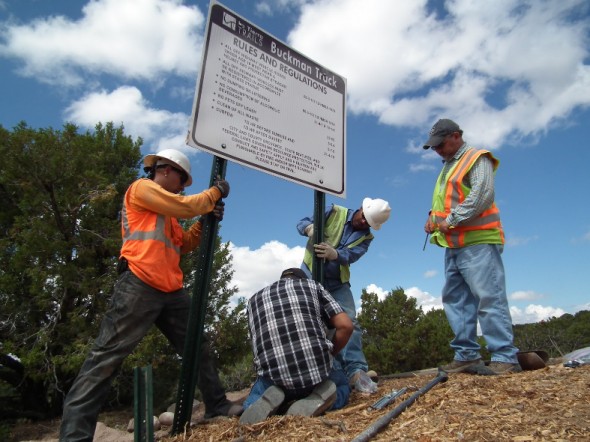 workers installing signs at motocross park